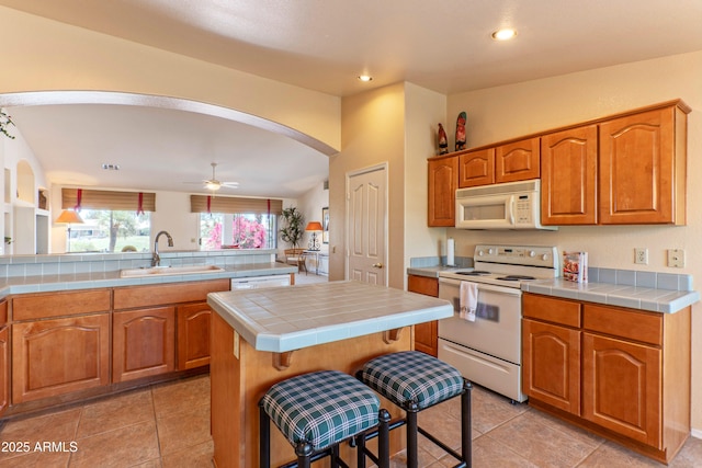 15371 W Piccadilly Rd, Goodyear, AZ 85395 - kitchen with a sink, white appliances, recessed lighting, arched walkways, and tile counters