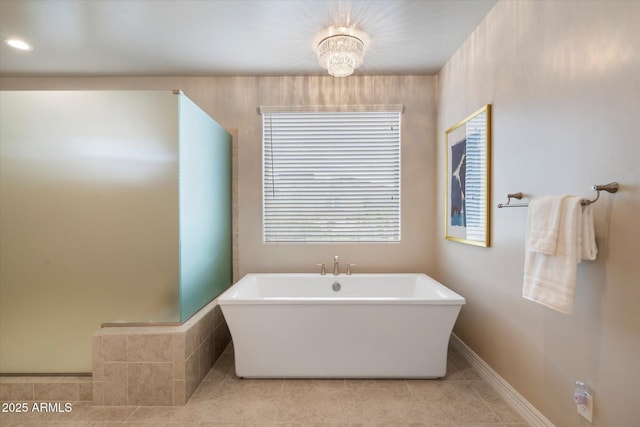 8597 E Arroyo Seco Rd, Scottsdale, AZ 85266 - full bath with a freestanding bath, tile patterned floors, baseboards, and an inviting chandelier
