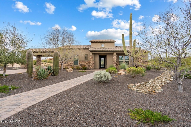 8597 E Arroyo Seco Rd, Scottsdale, AZ 85266 - mediterranean / spanish home with stone siding, a tiled roof, and stucco siding