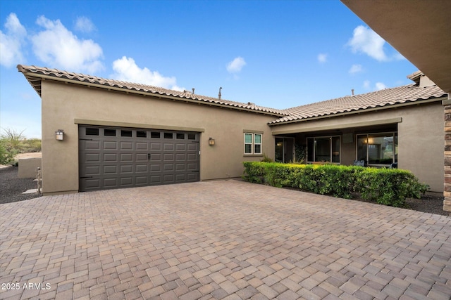 8597 E Arroyo Seco Rd, Scottsdale, AZ 85266 - view of front of house featuring a garage, a tile roof, decorative driveway, and stucco siding
