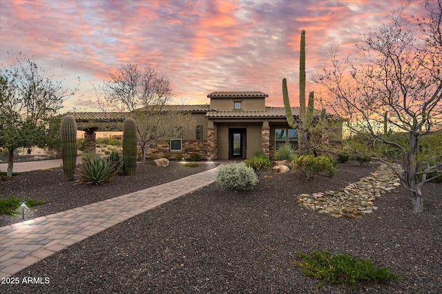 8597 E Arroyo Seco Rd, Scottsdale, AZ 85266 - mediterranean / spanish-style home featuring stone siding, a tile roof, and stucco siding