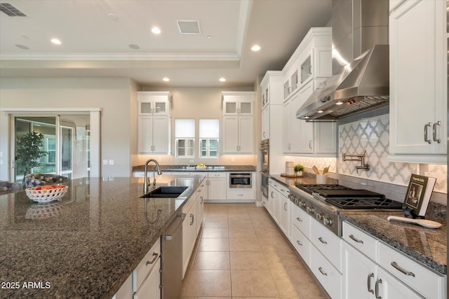 8597 E Arroyo Seco Rd, Scottsdale, AZ 85266 - kitchen with stainless steel appliances, a sink, tasteful backsplash, visible vents, and wall chimney range hood