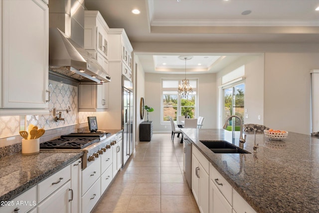 8597 E Arroyo Seco Rd, Scottsdale, AZ 85266 - kitchen with stainless steel appliances, a sink, tasteful backsplash, wall chimney range hood, and a raised ceiling