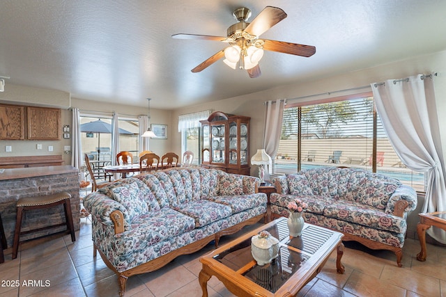 living room featuring ceiling fan and a textured ceiling