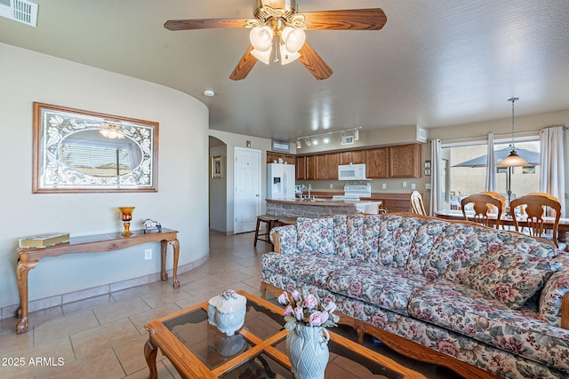 living room with rail lighting, sink, light tile patterned floors, and ceiling fan