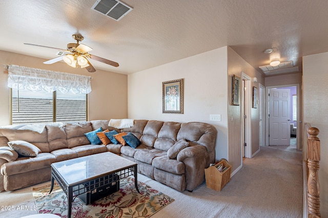 living room with ceiling fan, light carpet, and a textured ceiling