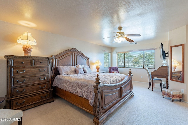 carpeted bedroom with ceiling fan and a textured ceiling