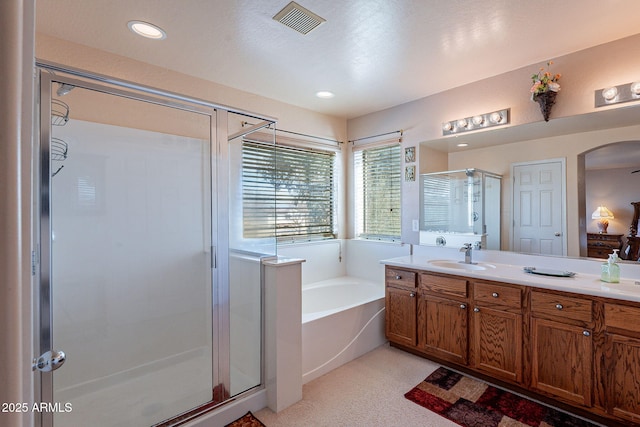 bathroom featuring vanity and independent shower and bath