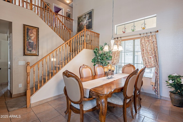 dining space with an inviting chandelier and a towering ceiling