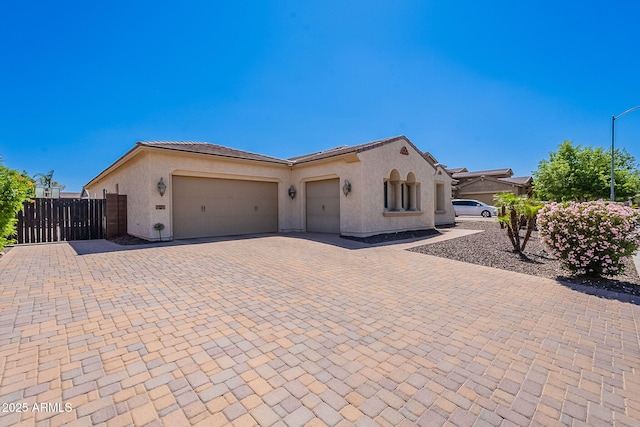 9345 W Robin Ln, Peoria, AZ 85383 - mediterranean / spanish home featuring an attached garage, stucco siding, decorative driveway, and a tile roof