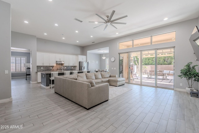 9345 W Robin Ln, Peoria, AZ 85383 - living area with a ceiling fan, a high ceiling, baseboards, plenty of natural light, and light wood finished floors