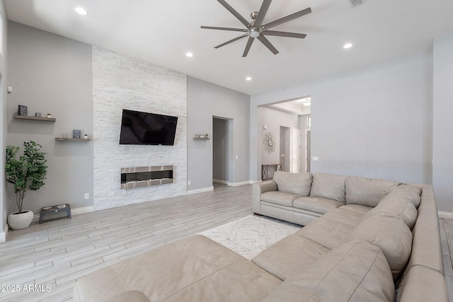 9345 W Robin Ln, Peoria, AZ 85383 - living area featuring ceiling fan, wood finished floors, recessed lighting, a stone fireplace, and baseboards