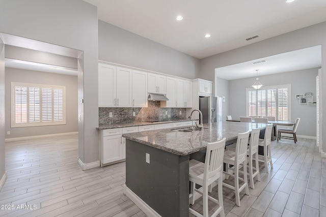 9345 W Robin Ln, Peoria, AZ 85383 - kitchen featuring a sink, stainless steel fridge, baseboards, wood finish floors, and white cabinetry