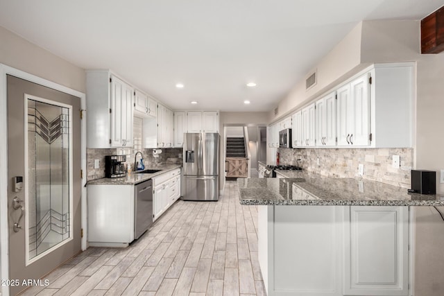 5484 E 36th Ave, Apache Junction, AZ 85119 - kitchen with stainless steel appliances, light stone counters, a peninsula, white cabinets, and recessed lighting