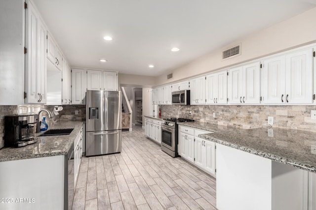 5484 E 36th Ave, Apache Junction, AZ 85119 - kitchen with stainless steel appliances, stone counters, white cabinetry, backsplash, and recessed lighting