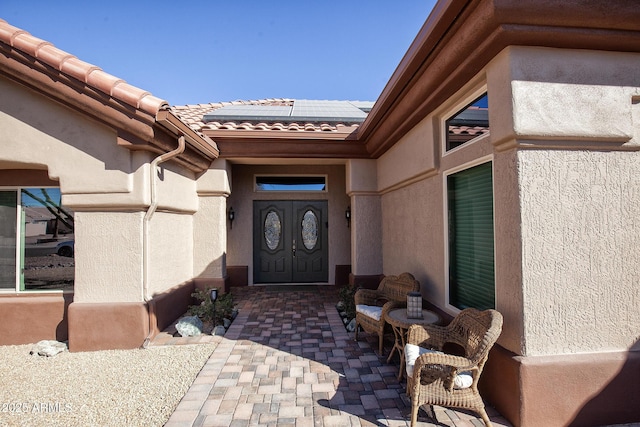 property entrance featuring a patio and solar panels