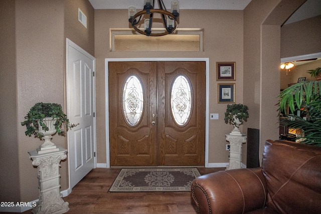 entryway with a chandelier and dark hardwood / wood-style floors