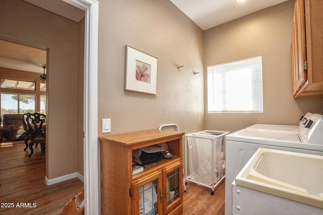 clothes washing area featuring independent washer and dryer, hardwood / wood-style flooring, a healthy amount of sunlight, and sink