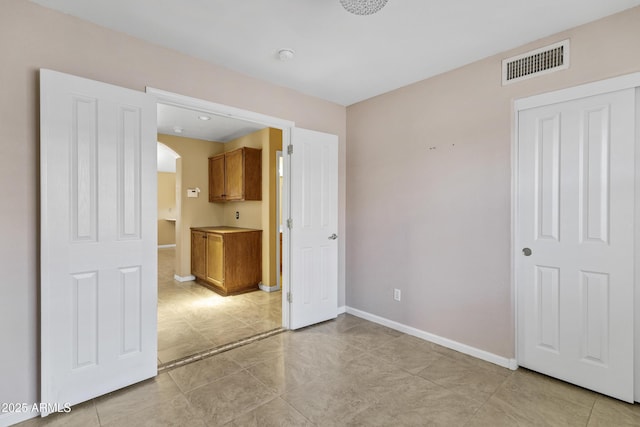 625 W Douglas Ave, Gilbert, AZ 85233 - unfurnished bedroom featuring arched walkways and light tile patterned floors