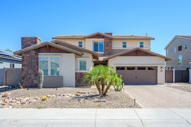 3247 E Creosote Ln, Gilbert, AZ 85298 - view of front of home with decorative driveway, an attached garage, stucco siding, a chimney, and stone siding