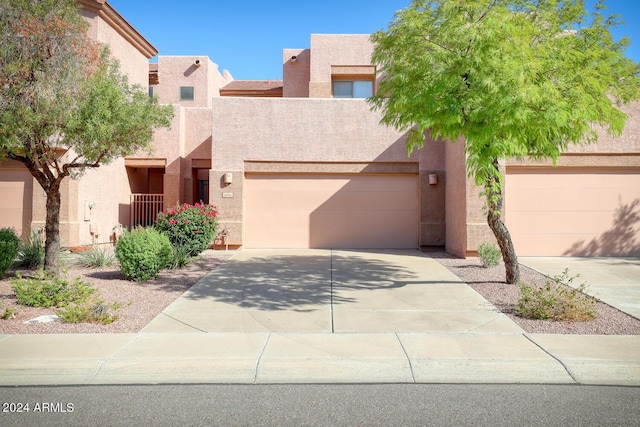 pueblo-style home featuring a garage