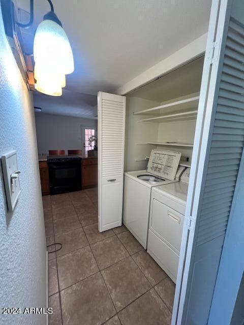 laundry area featuring washer and clothes dryer and tile patterned flooring