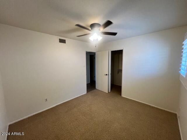 unfurnished bedroom featuring ceiling fan, a closet, and carpet floors