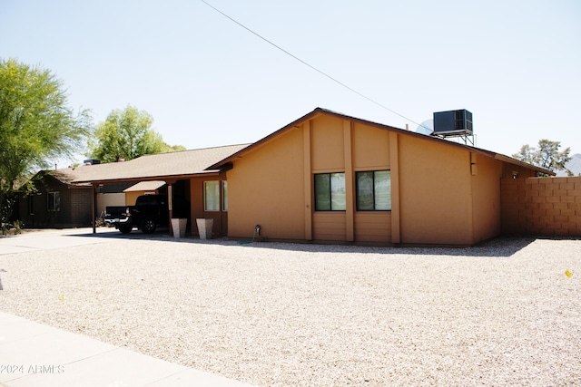 view of property exterior featuring a carport and central AC