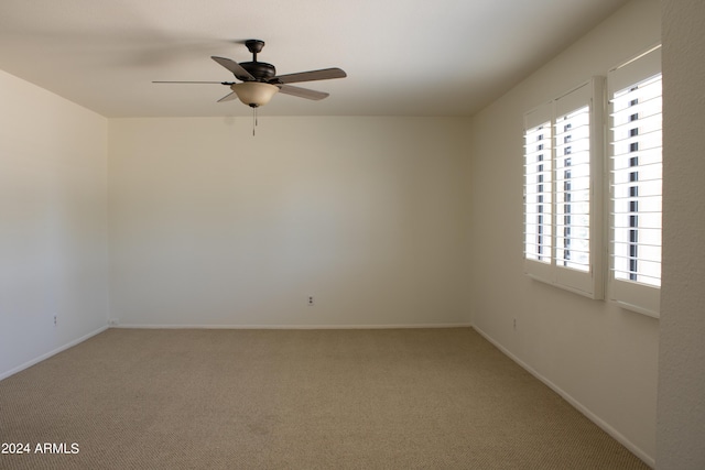 carpeted spare room with ceiling fan