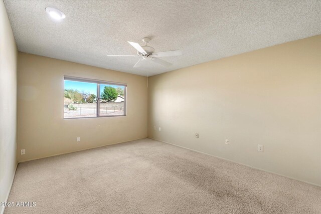 unfurnished room with light carpet, a textured ceiling, and a ceiling fan