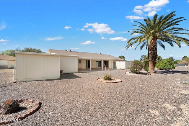 back of property featuring a patio and fence