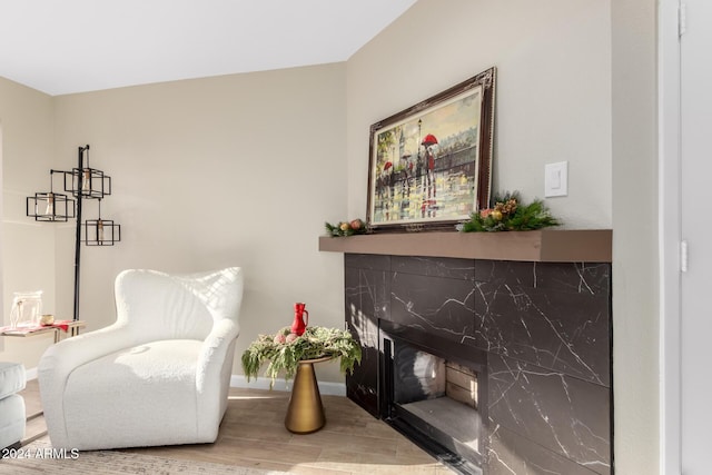 sitting room with hardwood / wood-style floors and a high end fireplace