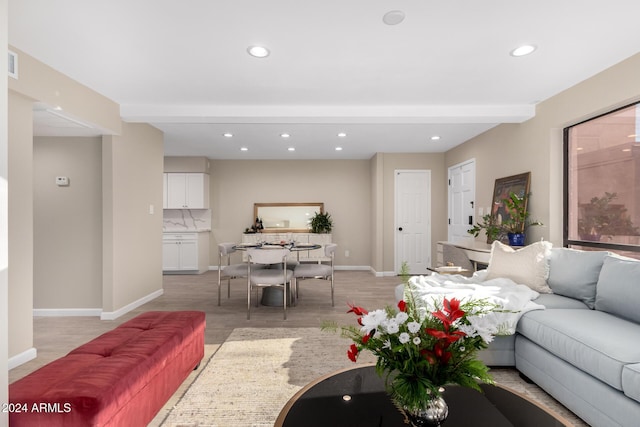 living room featuring beamed ceiling and light hardwood / wood-style floors