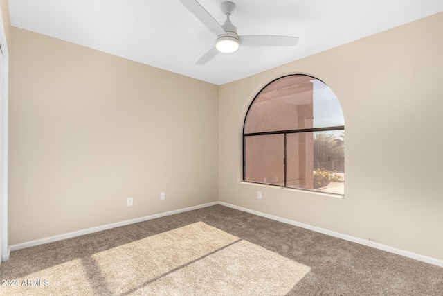 empty room with ceiling fan and carpet flooring