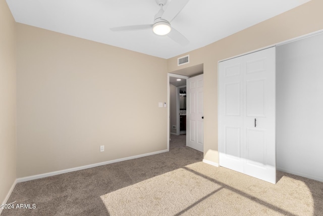 unfurnished bedroom with ceiling fan, a closet, and carpet