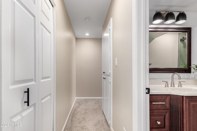 corridor featuring sink and light carpet