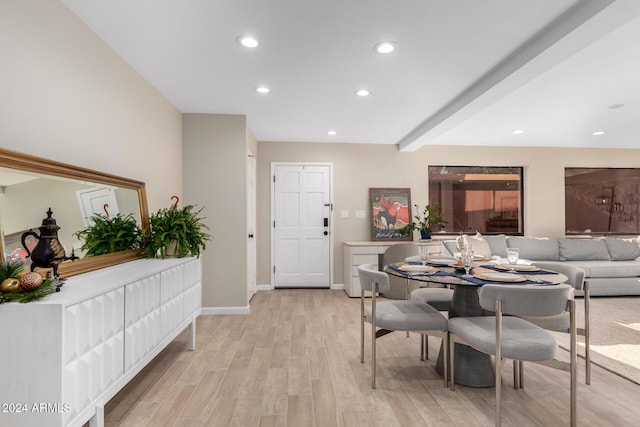 dining area featuring beamed ceiling and light wood-type flooring