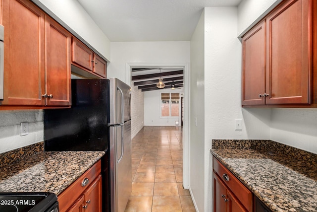 4414 E Hubbell St Unit 66, Phoenix, AZ 85008 - kitchen with dark stone countertops, freestanding refrigerator, light tile patterned flooring, and beam ceiling