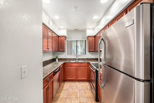 4414 E Hubbell St Unit 66, Phoenix, AZ 85008 - kitchen featuring appliances with stainless steel finishes, a textured wall, light tile patterned floors, recessed lighting, and dark stone counters