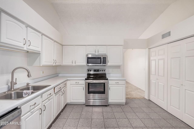 kitchen featuring white cabinetry, stainless steel appliances, visible vents, and a sink