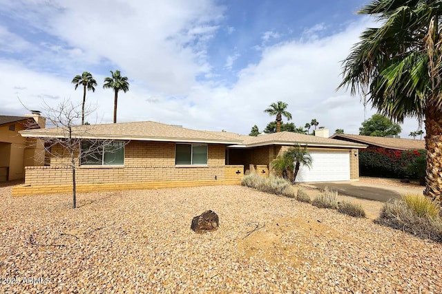 ranch-style home with an attached garage, brick siding, and driveway