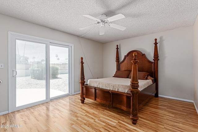 bedroom featuring light hardwood / wood-style flooring, a textured ceiling, access to outside, and ceiling fan