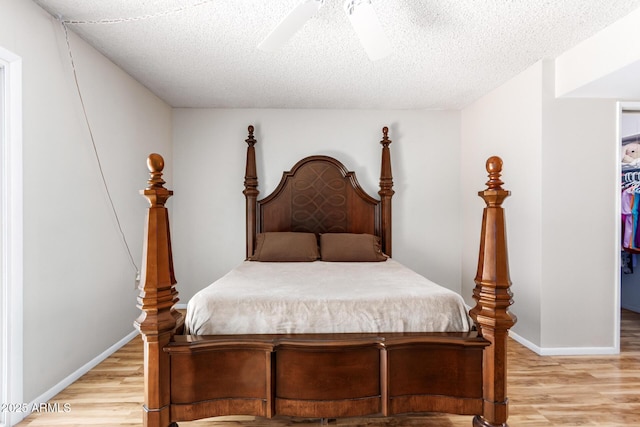 bedroom featuring ceiling fan, a textured ceiling, and light wood-type flooring