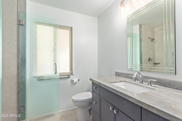 bathroom with a shower with door, vanity, tile patterned floors, and toilet