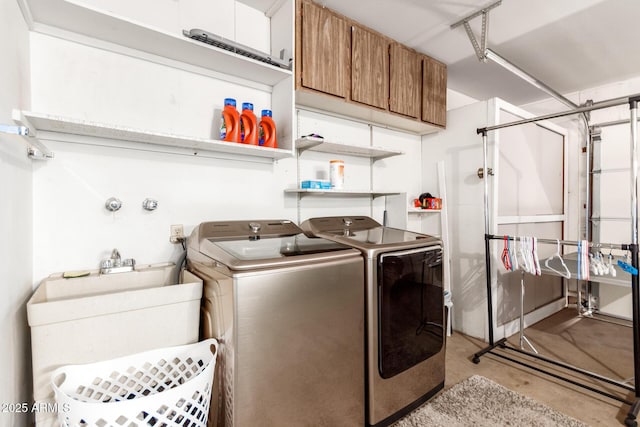 clothes washing area featuring cabinets, washer and dryer, and sink