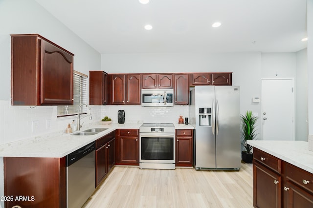 2402 E 5th St Unit 1498, Tempe, AZ 85288 - kitchen featuring appliances with stainless steel finishes, a sink, light wood-style flooring, backsplash, and recessed lighting