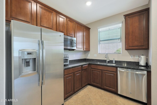 kitchen with dark stone countertops, sink, and stainless steel appliances