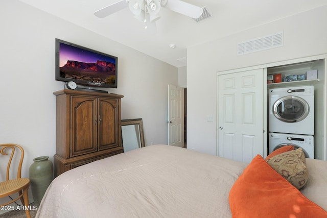 bedroom featuring a closet, ceiling fan, and stacked washing maching and dryer