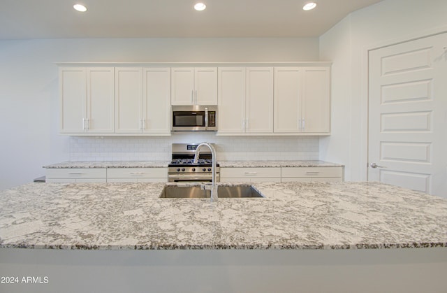 2228 E Isaiah Ave, Gilbert, AZ 85298 - kitchen featuring stainless steel appliances, white cabinetry, a sink, tasteful backsplash, and recessed lighting