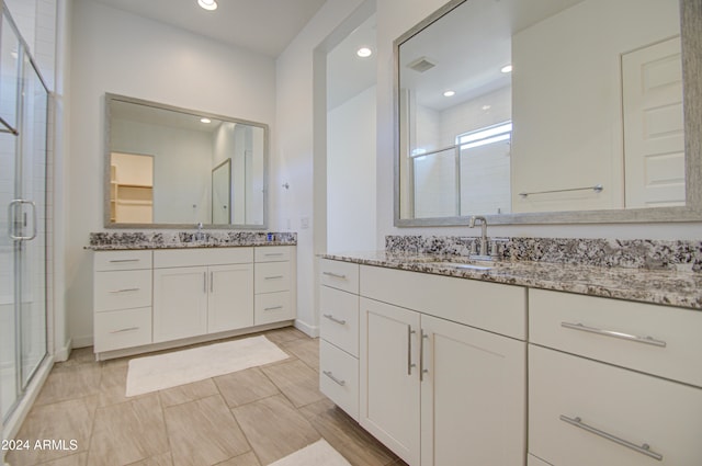 bathroom featuring vanity and a shower with shower door